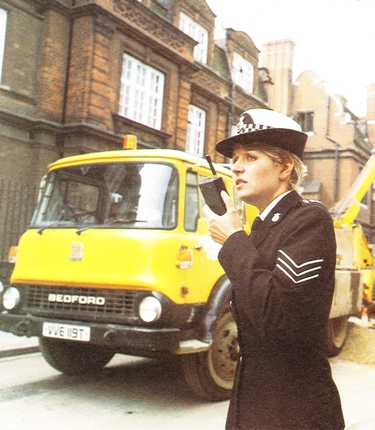 Policewoman using a Pye PF85 portable
                            two-way radio